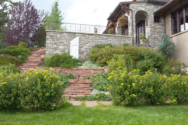 Flowering shrubs, stone walls, and red sandstone walkways and stairs